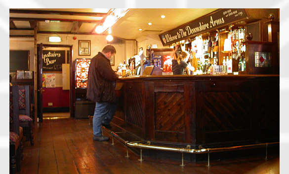 a view of the wood, brass and glass inside the Devonshire Arms pub... a patron waits while the bar maid fills his draught